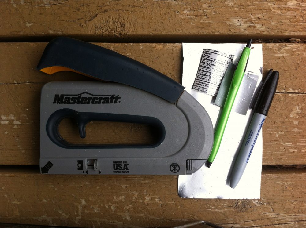 A staple gun is used to attach labels to the logs. Cut up aluminum cans work well. Use a ballpoint to etch the information and a sharpie to make it more easy to read.